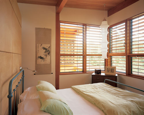 The bedroom creates a snug private space, completing the international flavor of the home with an Italian-designed hanging lamp and a wall hanging from China.